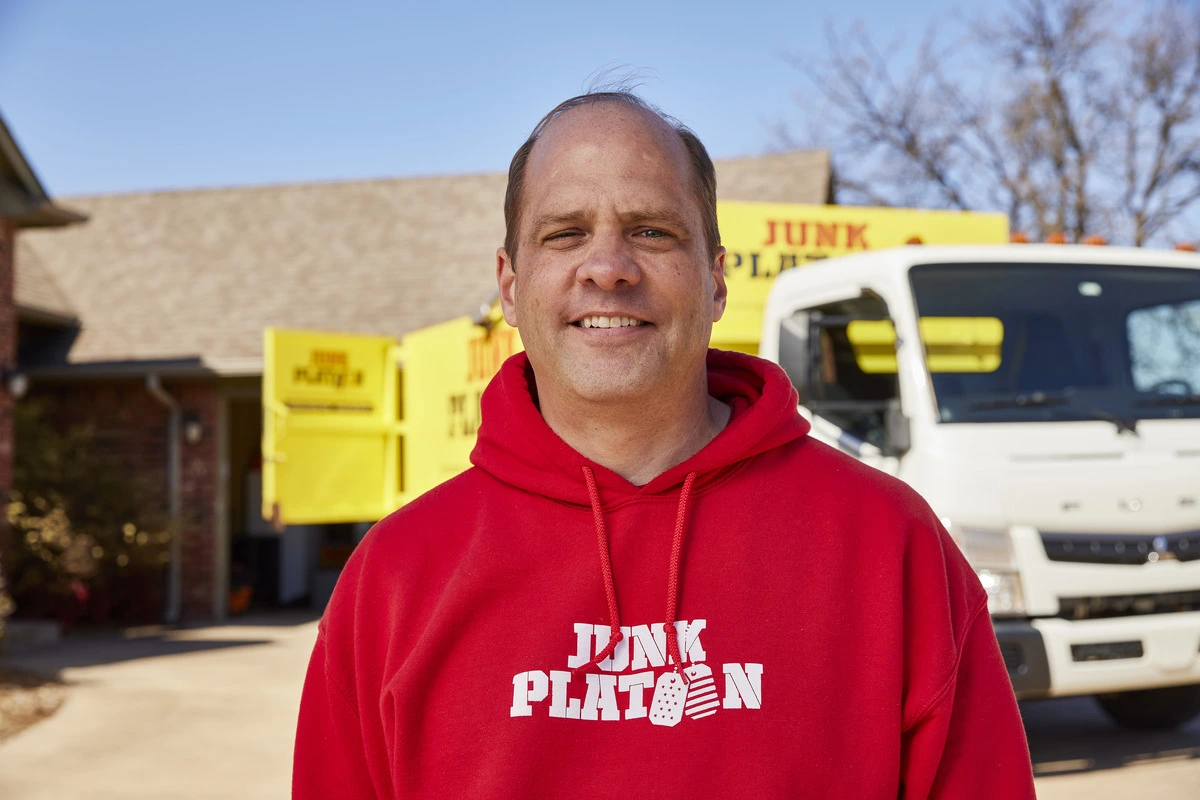 Man standing in front of a house and truck smiling for the camera